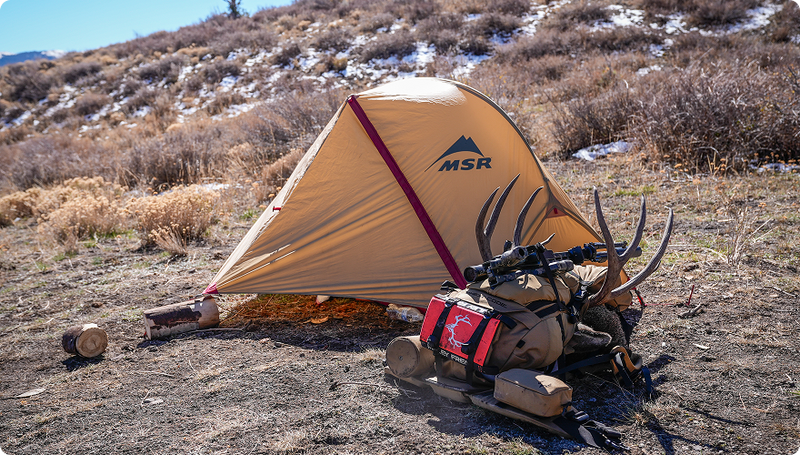 Muley Freak Cheat Code hunting backpack at backcountry camp with gear for extended hunting trips.